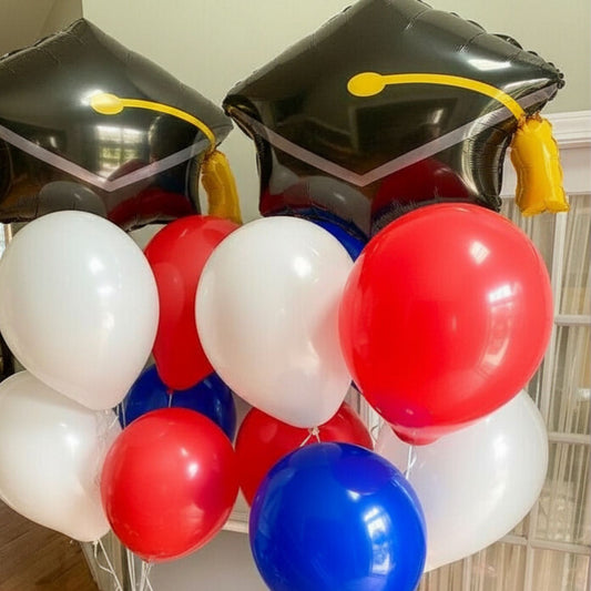 Graduation-themed balloons with black caps and colorful balloons indoors.