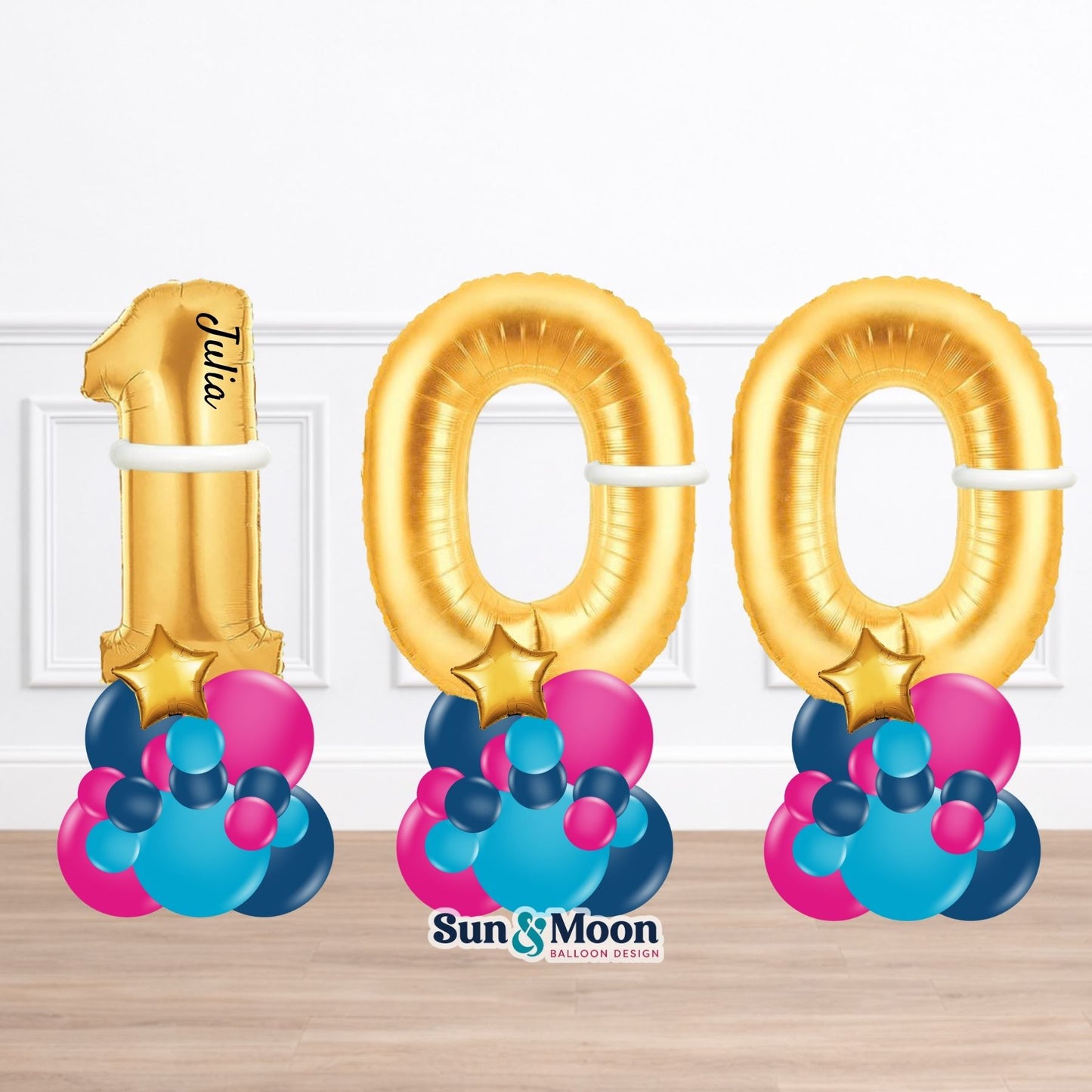 Gold number balloons spelling '100' with colorful bases on a white background
